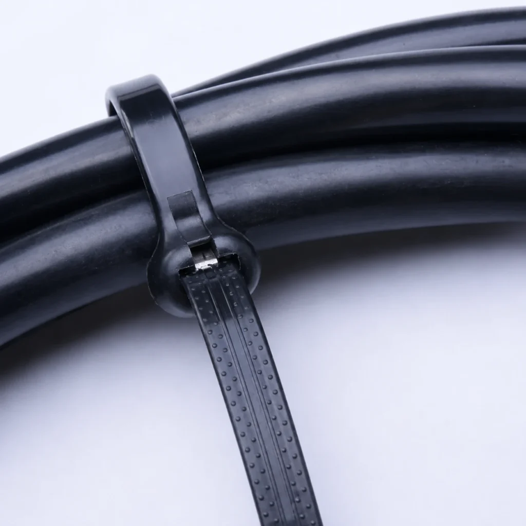 Close up of black metal pawl cable tie securing thick black cables